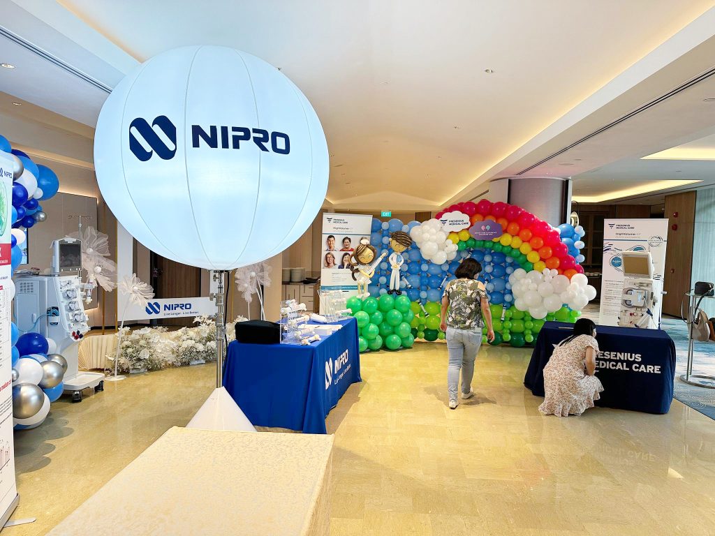 Lighted balloon stand with rainbow balloon wall backdrop