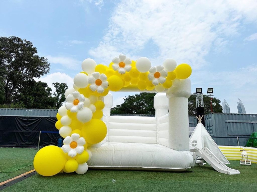 white bouncy castle with yellow floral garland