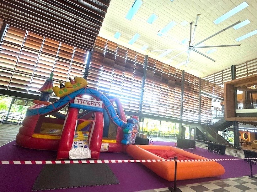 Carnival-themed bouncy castle Singapore with slide and ball pit at indoor venue