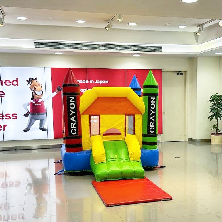 Crayon themed bouncy castle rental at an indoor showroom event in Singapore