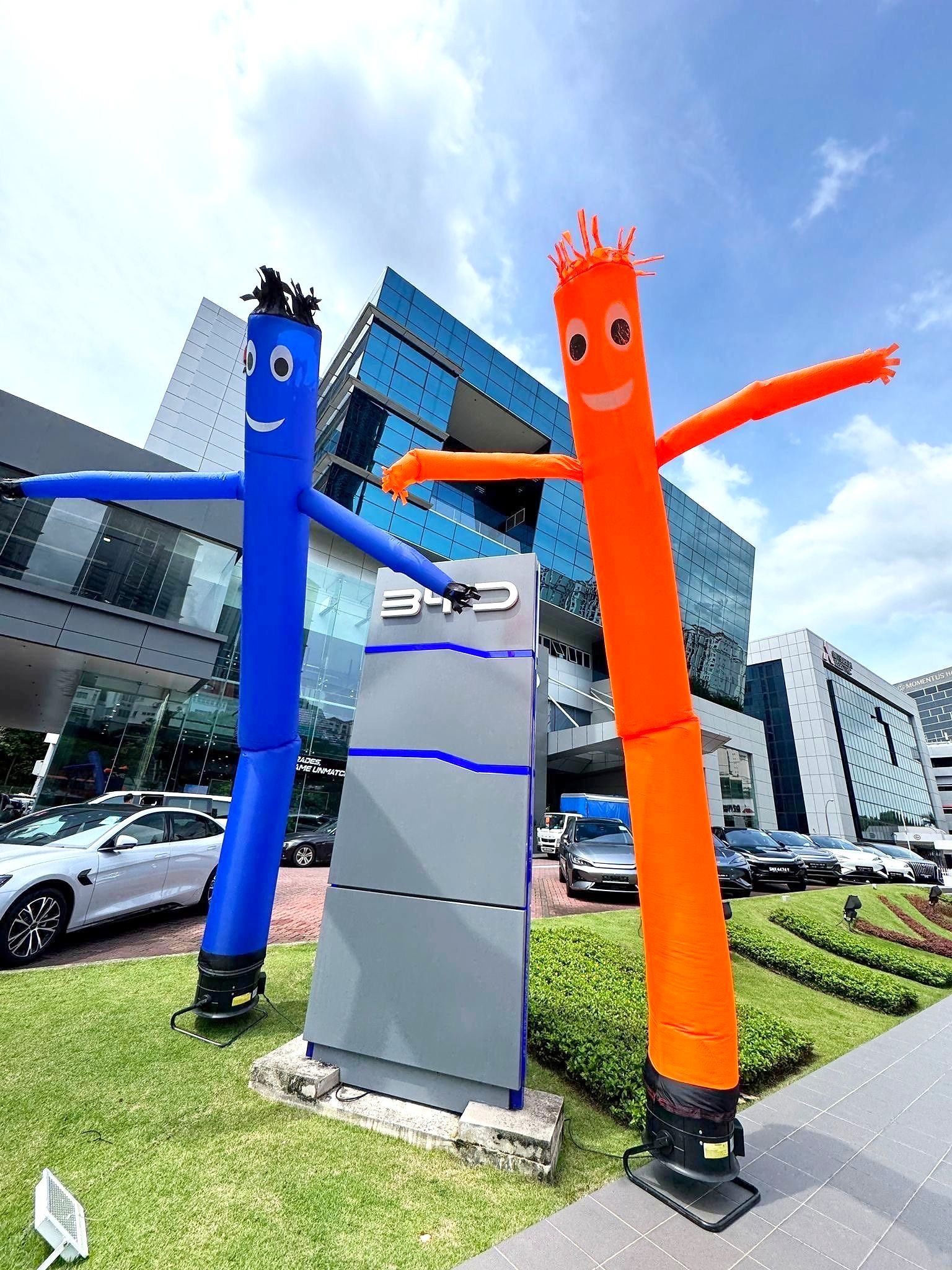 Blue and orange air dancers beside a car showroom sign