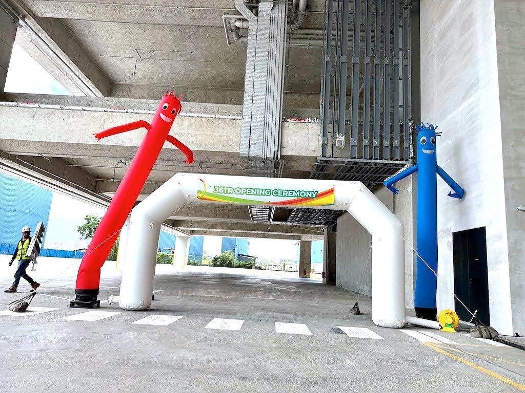 White opening ceremony inflatable arch between red and blue air dancers