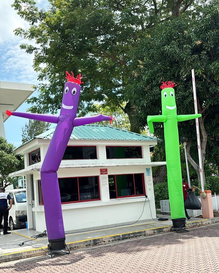 Purple and green air dancers in an outdoor welcome area