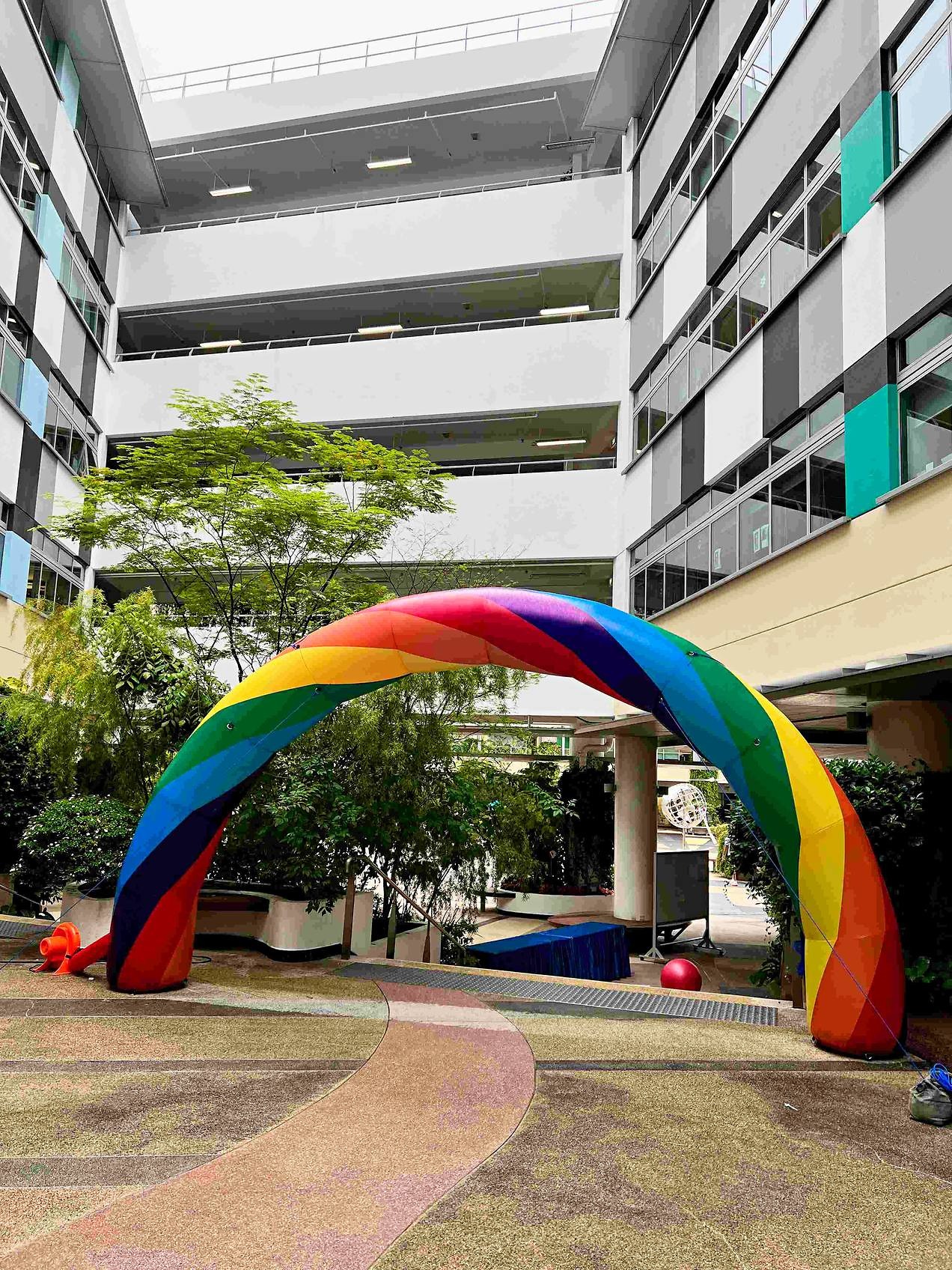 Portrait view of a rainbow inflatable arch in a courtyard